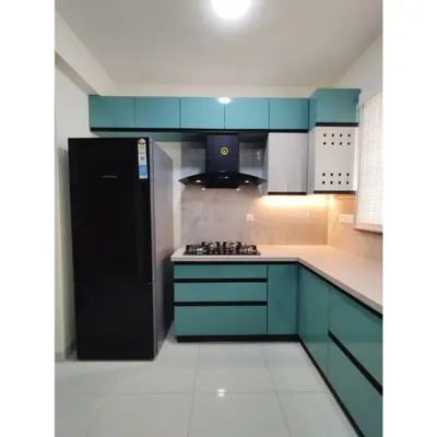 A complete view of the U-shaped kitchen in #TheDivinityHome. The layout is designed for efficiency, with the stove, sink, and refrigerator forming a perfect work triangle. The teal and white cabinetry adds a fresh, modern look.