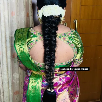 A classic South Indian bridal braid, neatly woven and decorated with traditional pearl accessories. This style is elegant and perfectly complements a silk saree.
