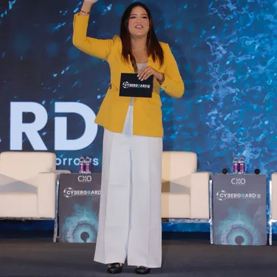 Waving to the crowd as I take the stage at the Cyberguard Summit. Hosting for the IT sector requires a sharp, energetic presence to match the innovative spirit of the industry.