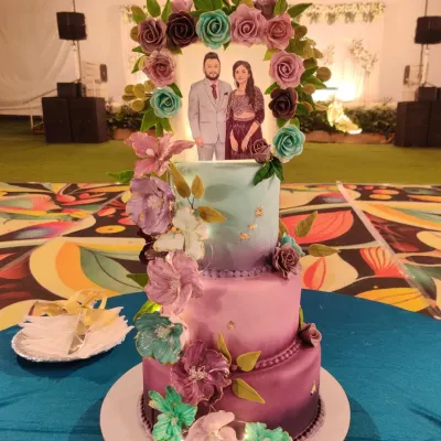 Baking for family is a special kind of pressure and pleasure. This two-tiered wedding cake, with its custom couple topper and cascade of handmade sugar flowers in shades of purple and teal, was an honor to create for my nephew and his bride.