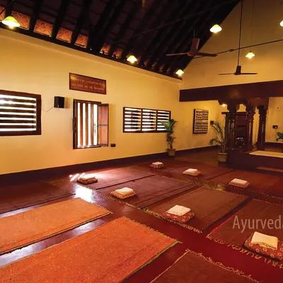 Our peaceful indoor yoga hall, prepared for a session. The space is designed with traditional architecture and natural materials to create a grounding and harmonious environment for practice.
