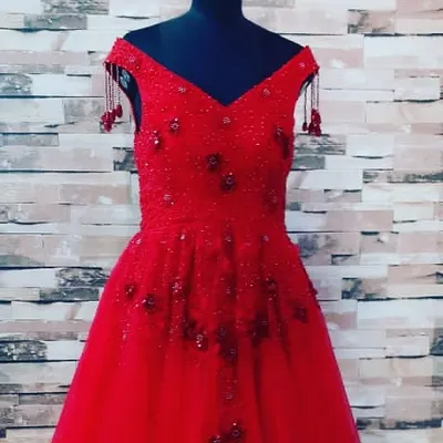 This is a full-length view of a custom-designed red party gown. The off-shoulder style and full skirt are perfect for birthdays and formal events, and the finishing is very clean.