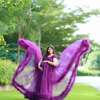 Our purple flying gown adds a touch of magic to maternity photos. The wing like trails create a dramatic, ethereal effect, perfect for an outdoor shoot.