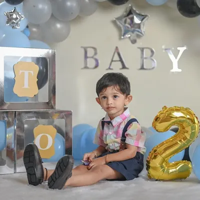 Celebrating the big TWO! This birthday setup features a balloon arch and letter blocks spelling out 'TWO'. It's a fun and festive way to capture your toddler's personality as they celebrate their second birthday.