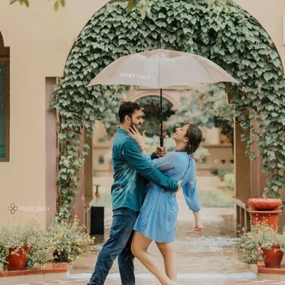 A classic Bollywood-style romance shot in the rain. The couple shares an umbrella and a dance, creating a moment that is both playful and deeply romantic.
