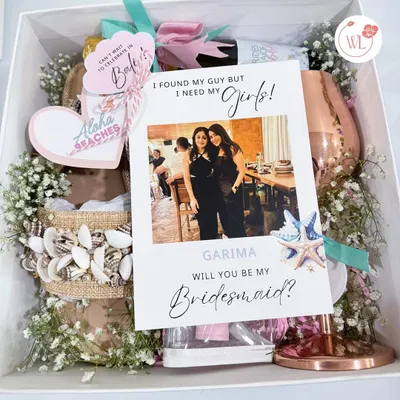 The ultimate bridesmaid proposal box for a destination bachelorette in Bali. It includes a personalized card, shell-decorated flip-flops, a custom wine glass, and other themed goodies.