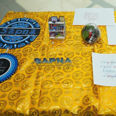 A beautiful display of crafts from our various workshops, including intricate Mandala art and a miniature bookshelf, showcasing the diverse skills we teach.