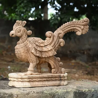 An exquisitely carved wooden parrot statue with a natural finish. In Hindu tradition, the parrot symbolizes truth and love, making this a beautiful and meaningful decorative piece.