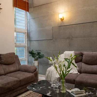 A double-height ceiling allows for dramatic design elements, like this textured grey panel wall, which adds depth and character to the living space.