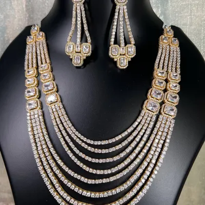 This is a stunning multi-layered American diamond necklace in a silver and gold dual-tone finish. It's a grand piece to rent for a wedding or reception, giving you a full and luxurious look.