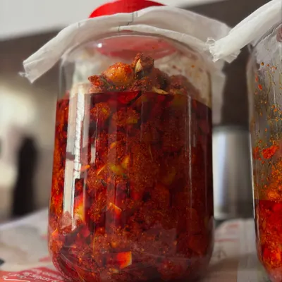 A jar of my classic mango pickle, slowly curing on my kitchen shelf. This process allows the flavours of the raw mango and spices to meld together naturally over time.