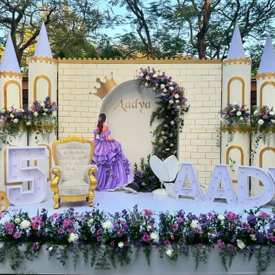 A beautiful Sofia the First themed 5th birthday party, featuring a full castle facade, a golden throne for the birthday girl, and large light-up letters spelling her name.