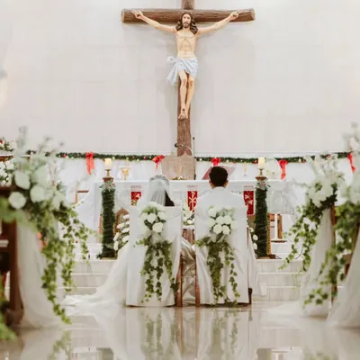 A powerful and serene moment as Ryan and Ela kneel before the altar. The decor is intentionally kept elegant and minimal with white florals, ensuring the focus remains on the sanctity of their vows and the beautiful church architecture.