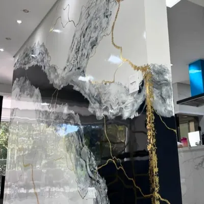 A luxurious, high-gloss marble effect painted directly onto the wall, featuring dramatic black and gold veins. This is a premium finish for a sophisticated living or commercial space.