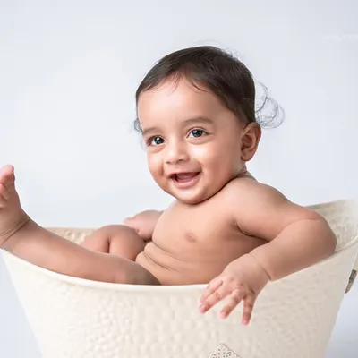 Pure happiness in a tub! This simple and joyful shot captures the fun of a splash session, a favorite part of the first birthday photoshoot experience.