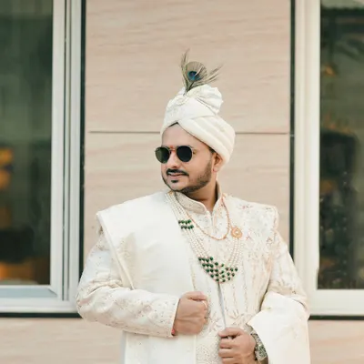 A stylish portrait of the groom. We capture the groom's personality and dapper style, complete with sunglasses and a peacock feather on his safa.