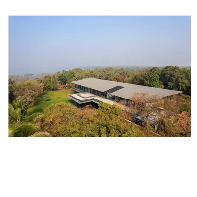 An aerial view of the Lakeshore house, nestled within its 50 acre site on Lake Osman Sagar. The structure is designed to be a subtle insertion into the geological history of the place, respecting the rocks and trees that were there long before us.