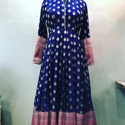 A grand Anarkali stitched from a royal blue brocade saree. The design includes a high neck and uses the saree's pallu for the contrasting cuffs, perfect for weddings.