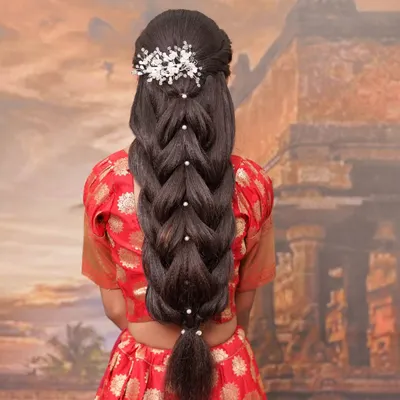 A back view of an advanced, multi-strand braid. This intricate hairstyle is adorned with pearls, making it a stunning choice for a reception or any grand celebration.