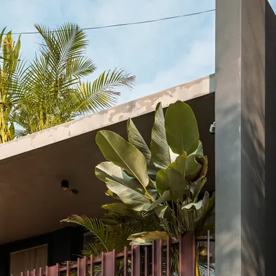 The cantilevered roof of the 'Ittige' residence provides shade while allowing lush tropical plants to thrive, blurring the line between the building and its garden.