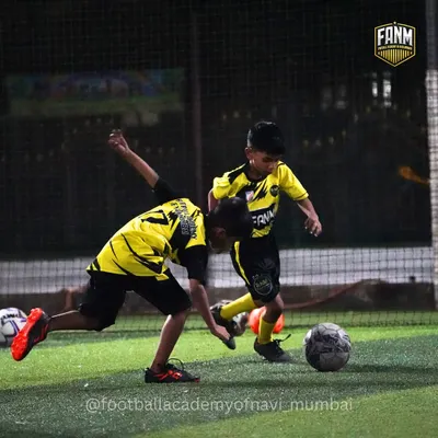 Two young players battle for the ball in a practice match. I encourage healthy competition and teach players how to tackle fairly and effectively.