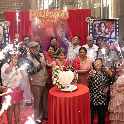 Lights, Camera, Action! For a 60th birthday, I designed a 'Bollywood Night' theme, complete with a red curtain backdrop, film reel details, and sparklers for a dramatic cake-cutting moment.