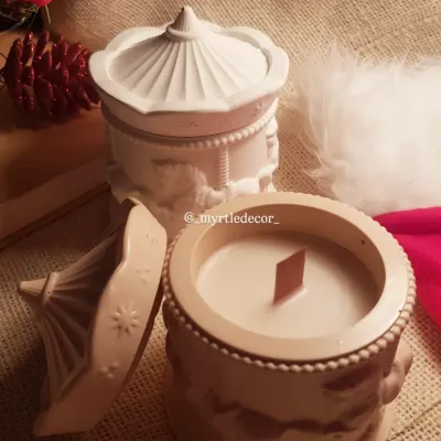 Our Carousel Christmas jar candle, shown here with its lid off to reveal the hand-poured soy wax and wooden wick inside. The intricate carousel horse details on the Jesmonite jar are meant to evoke a sense of nostalgia and festive wonder.