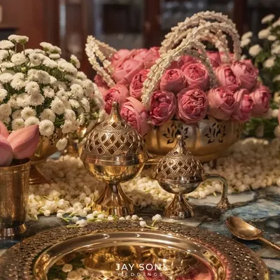 Every detail matters. This close-up shows the intricate craftsmanship of a traditional table setting, with embossed brass plates, lotus bud accents, and ornate incense holders, all contributing to a feeling of royal elegance.