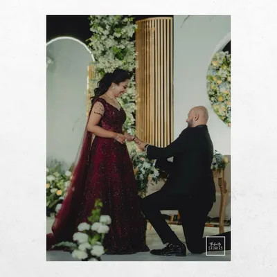 The classic proposal moment, captured forever. This shot focuses on the emotion and significance of the ring exchange during a beautifully decorated engagement event.