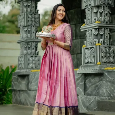 This flowy, floor-length gown was crafted from a client's treasured silk saree. I designed it with a fully pleated skirt to create beautiful movement, carefully preserving the original dark blue and gold border along the hemline.