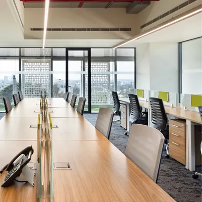 For the APT office in New Delhi, we prioritized natural light and open sightlines. The long communal workstations are positioned to give employees expansive views, while low partitions maintain a sense of personal space without sacrificing the open, collaborative feel.
