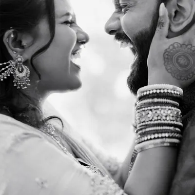 A moment of pure, uninhibited laughter between a couple. Black and white enhances the raw emotion and connection in this candid shot.