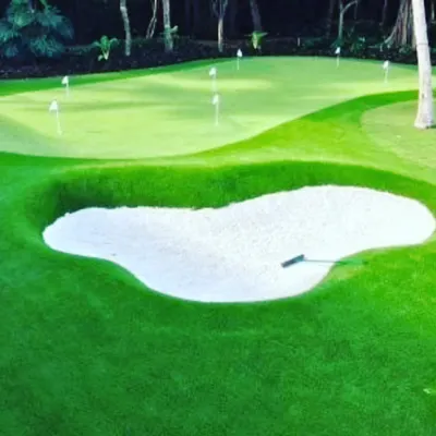 A custom putting green with a professionally installed sand trap. The deep bunker adds a challenge for your short game practice, surrounded by lush fringe turf.