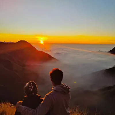 A couple watching the sunrise over a blanket of clouds in Munnar. This is the kind of romantic and peaceful moment my trips are made for.