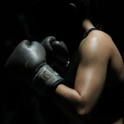 The focus and determination of a boxer. This shot captures the intensity of our boxing training, where you learn to channel your strength and energy into powerful, controlled movements.