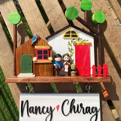 This is my top-selling diorama design, and it’s easy to see why. It features two little houses, a miniature couple, and vibrant, hand-painted details like the lemon vine and red fence. The hanging name board with hooks for keys makes it as functional as it is charming.