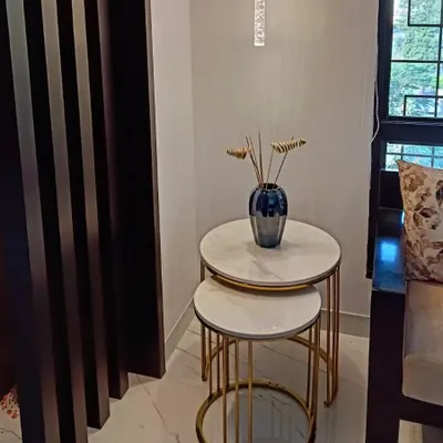 A set of two nesting coffee tables featuring white marble tops and ribbed tube bases with a gold electroplating finish. Their compact and versatile design makes them ideal for smaller spaces or as side tables.