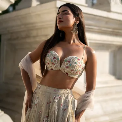 Presenting the Ivory Edit. This stunning lehenga features a floral embroidered bustier, showcasing the exquisite handwork and craftsmanship of our collection.