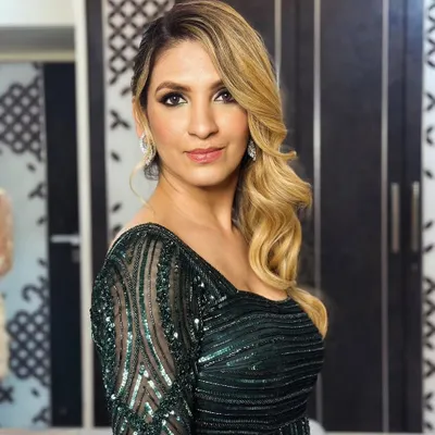 This one-shoulder gown in a trendy emerald green is a perfect example of my detailed handwork. The bodice and sleeve feature intricate, intersecting lines of self-colored cutdana, sequins, and salis for a sophisticated, modern look.