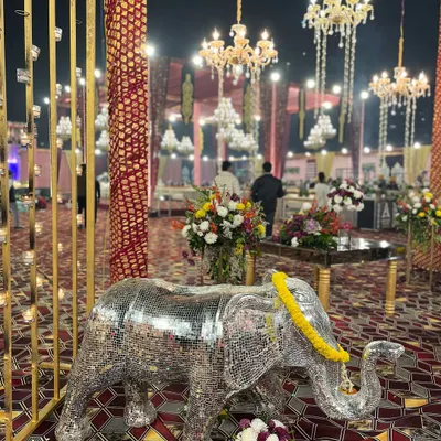 A stunning mirrored elephant statue, adorned with a marigold garland, adds a touch of modern royalty and is a favorite photo spot for guests.