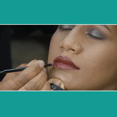 An extreme close-up showing the application of lipstick. This type of behind-the-scenes shot is perfect for a makeup artist's portfolio to show their technique.