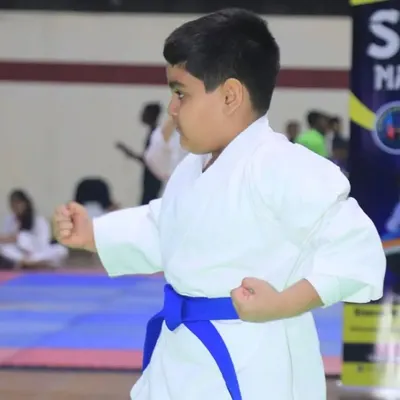 A young student demonstrates a perfect karate stance during a competition. We focus on teaching proper form and discipline from the very beginning.
