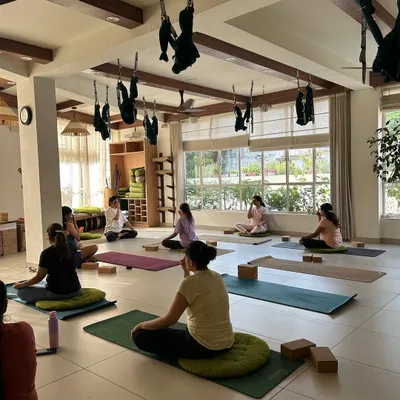 A typical class at our Yogshala. In the bright, sunlit space, members are seated on their mats, ready for a session of pranayama and meditation. The atmosphere is calm and focused.
