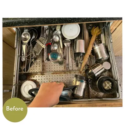 A "before" shot of a typical kitchen cutlery drawer. It's a jumble of spoons, ladles, and other tools, making it hard to find what you're looking for.