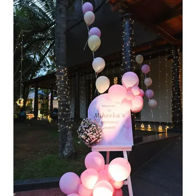 A beautiful evening entrance for Miheeka's birthday party. A personalized welcome sign is surrounded by illuminated pink balloons and twinkling fairy lights.