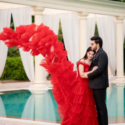 The magic of a flowing red gown. This shot is all about drama and elegance, with the dress creating a beautiful wave of color against the classic white columns and tranquil pool.