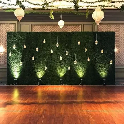I created this elegant event backdrop using a large artificial hedge wall. Decorated with hanging lanterns and uplighting, it provides a beautiful and sophisticated photo opportunity for weddings, parties, or corporate events.