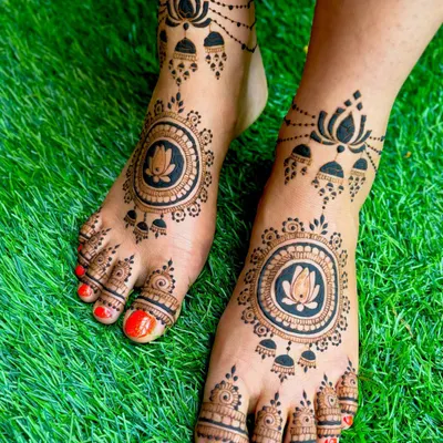This design features a bold lotus mandala on the top of the foot, paired with traditional jhumka and lotus motifs around the ankle for an ornate finish.
