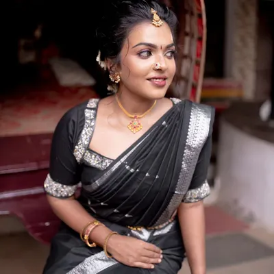 A bold and beautiful look for a model shoot. The black saree with silver accents is paired with a modern, chic hairstyle and makeup that highlights her strong features.