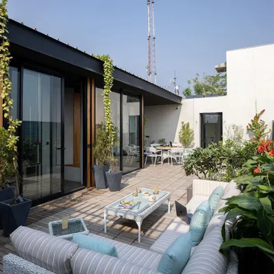 The terrace garden for a Delhi executive suite serves as a lush, open-air extension of the office. It provides a serene space for informal meetings or quiet contemplation during a hectic workday.